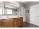 Double vanity bathroom with wood cabinets and large mirror at 17395 W Straight Arrow Ln, Surprise, AZ 85387