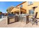 Outdoor kitchen features a built-in grill, refrigerator, and bar seating at 17395 W Straight Arrow Ln, Surprise, AZ 85387