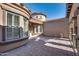 Private courtyard entrance with brick pavers and arched windows at 18088 W Narramore Rd, Goodyear, AZ 85338