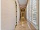 Light-filled hallway with tile floors and plantation shutters at 18088 W Narramore Rd, Goodyear, AZ 85338