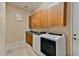 Laundry room with washer, dryer, and wood cabinets at 18088 W Narramore Rd, Goodyear, AZ 85338
