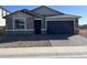 Single-story home with gray exterior, two-car garage, and landscaped front yard at 21641 N Daniel Dr, Maricopa, AZ 85138