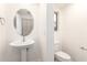 Small bathroom with pedestal sink, toilet, and oval mirror at 3956 E Tanzanite Ln, San Tan Valley, AZ 85143