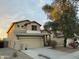 Two story house exterior with tan siding and a two car garage at 4112 S 249Th Dr, Buckeye, AZ 85326