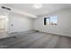 Bright and airy basement room with grey carpet and white brick accent wall at 6423 W Catalina Dr, Phoenix, AZ 85033