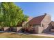 Tan two-story condo with a red tile roof, landscaping, and a large tree in front at 7430 N 43Rd Dr, Glendale, AZ 85301