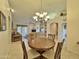 Bright dining room with a round table and four chairs, open to the living room at 11100 W Magdalena Dr, Arizona City, AZ 85123