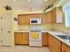 Kitchen features wood cabinets, white appliances, and yellow walls at 11100 W Magdalena Dr, Arizona City, AZ 85123