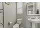Clean bathroom with pedestal sink, toilet and built-in shelving at 14575 W Orange Dr, Litchfield Park, AZ 85340