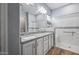 Double vanity bathroom with granite countertop and large mirror at 18852 N 260Th Ln, Buckeye, AZ 85396