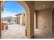 Archway view of the home's backyard, showing a tiled patio and desert landscaping at 18852 N 260Th Ln, Buckeye, AZ 85396
