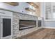 Modern electric fireplace with stone surround and floating shelves at 18852 N 260Th Ln, Buckeye, AZ 85396