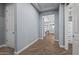 Interior hallway with gray walls, wood-look flooring, and white doors at 18852 N 260Th Ln, Buckeye, AZ 85396