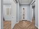 Interior hallway view with gray walls, herringbone flooring, and white doors at 18852 N 260Th Ln, Buckeye, AZ 85396