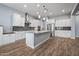 Modern kitchen with white cabinets, granite island, and stainless steel appliances at 18852 N 260Th Ln, Buckeye, AZ 85396