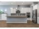 Modern kitchen with white cabinets, granite counters, and island at 18852 N 260Th Ln, Buckeye, AZ 85396