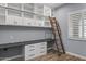 Built-in shelving and a desk with ladder access to upper shelving at 18852 N 260Th Ln, Buckeye, AZ 85396