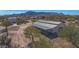 Aerial view of a property with a barn and riding arena, set against a mountain backdrop at 26620 N 141St St, Scottsdale, AZ 85262