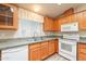 Bright kitchen with wood cabinets, white appliances, and a double sink at 3301 S Goldfield Rd # 2015, Apache Junction, AZ 85119