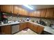 L-shaped kitchen with wooden cabinets and tiled backsplash at 3818 W Rose Ln, Phoenix, AZ 85019