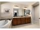 Elegant bathroom with double vanity and soaking tub at 16532 W Monte Vista Rd, Goodyear, AZ 85395