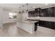 Modern kitchen with granite countertops, dark cabinetry, and stainless steel appliances at 18056 W Wolf St, Goodyear, AZ 85395