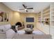 Cozy living room with a fireplace, built-in shelving, and ceiling fan at 2221 E Northview Ave, Phoenix, AZ 85020