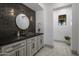 Bathroom with dark tile, floating vanity, and round mirror at 9732 N Fireridge Trl, Fountain Hills, AZ 85268
