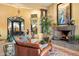 Living room with a fireplace, leather sofa, and access to outdoor patio at 9782 E Troon North Dr, Scottsdale, AZ 85262