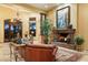 Living room with a fireplace, leather sofa, and large windows at 9782 E Troon North Dr, Scottsdale, AZ 85262