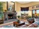 Living room with a fireplace and stunning views from large windows at 9782 E Troon North Dr, Scottsdale, AZ 85262