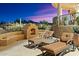 Outdoor patio with fireplace and seating area, offering stunning sunset views at 9782 E Troon North Dr, Scottsdale, AZ 85262