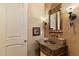 Powder room with dark granite countertop and decorative mirror at 9782 E Troon North Dr, Scottsdale, AZ 85262