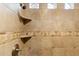 Shower with beige tile, built-in shelves, and decorative accents at 9782 E Troon North Dr, Scottsdale, AZ 85262