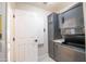 Laundry room with stacked washer, dryer, and built-in ironing board at 14741 W Avalon Dr, Goodyear, AZ 85395