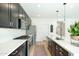 Modern kitchen with dark cabinetry, quartz countertops, and stainless steel appliances at 35184 N Magnette Way, San Tan Valley, AZ 85144