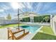 Relaxing pool area with patio furniture and umbrella at 35184 N Magnette Way, San Tan Valley, AZ 85144