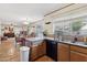 Kitchen with granite counters, wood cabinets, and views into the adjacent dining area at 4108 W Creedance Blvd, Glendale, AZ 85310