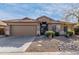 Tan house with tile roof, two-car garage, and desert landscaping at 42269 W Little Dr, Maricopa, AZ 85138