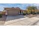 Tan house with tile roof, two-car garage, and a nicely landscaped yard at 42269 W Little Dr, Maricopa, AZ 85138