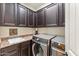 Laundry room with washer, dryer, and dark wood cabinets at 8443 E Jensen St, Mesa, AZ 85207