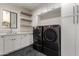 Laundry room with white cabinets and black herringbone floor at 11380 E Sand Hills Rd, Scottsdale, AZ 85255