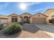 Tan one-story house with a two-car garage and landscaped yard at 13349 W Caribbean Ln, Surprise, AZ 85379