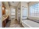 Main bathroom with soaking tub, walk-in shower, and double vanity at 2122 W Red Range Way, Phoenix, AZ 85085