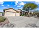 Two-car garage and driveway with landscaping and a large tree to the right at 2122 W Red Range Way, Phoenix, AZ 85085