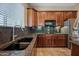 Kitchen features dark wood cabinets, granite countertops, and a large sink at 2122 W Red Range Way, Phoenix, AZ 85085