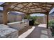 Outdoor kitchen with grill and stone countertop under a pergola at 4542 S Axis --, Mesa, AZ 85212