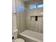 Bathroom with a bathtub, tiled walls, and a window at 6891 W Via Del Sol Dr, Glendale, AZ 85310
