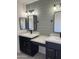 Modern bathroom with double vanity, dark cabinets, and green wall at 6891 W Via Del Sol Dr, Glendale, AZ 85310
