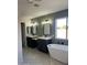 Spa-like bathroom with double vanity, soaking tub, and herringbone tile at 6891 W Via Del Sol Dr, Glendale, AZ 85310